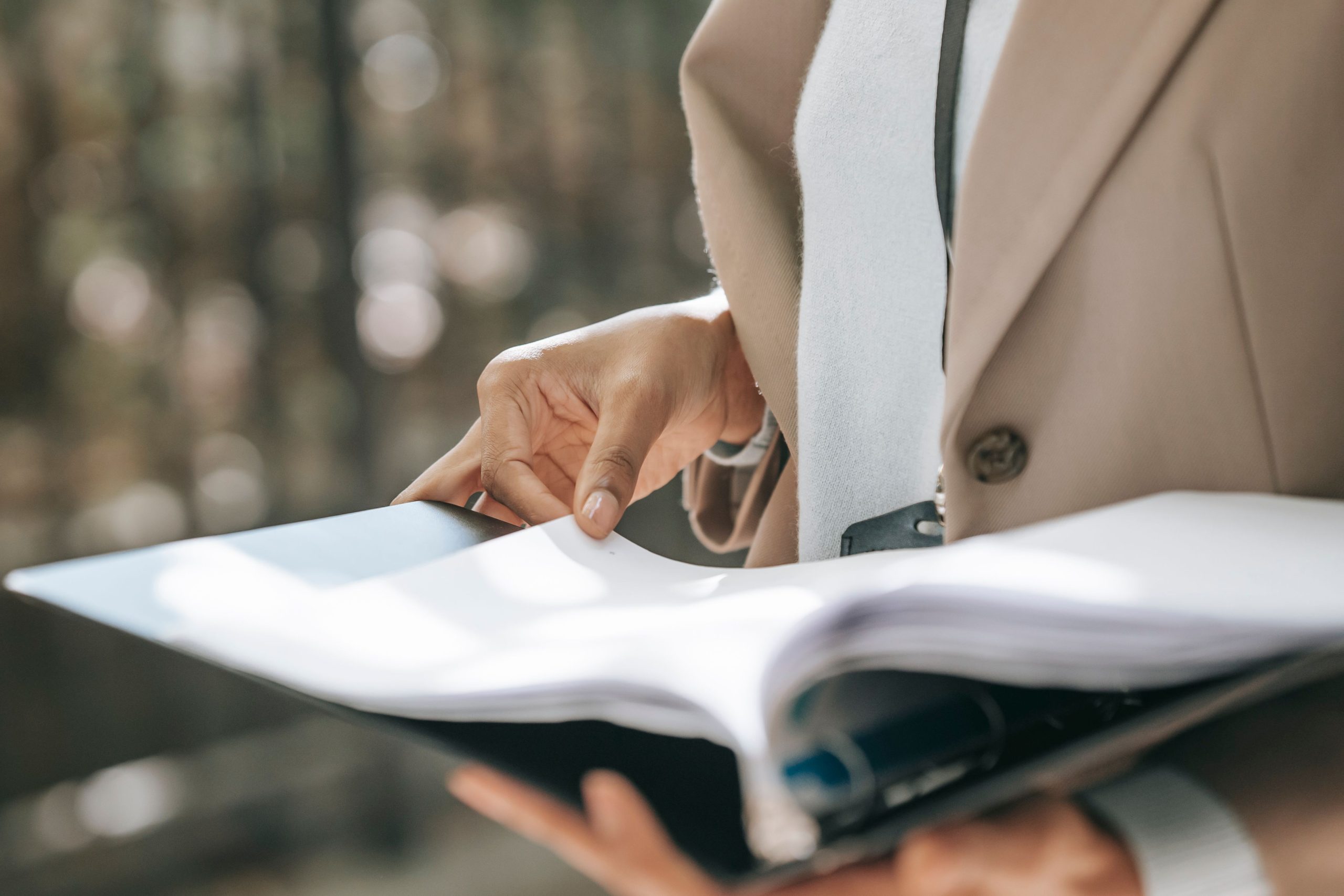 Businesswoman in a jacket reviewing property documents outdoors